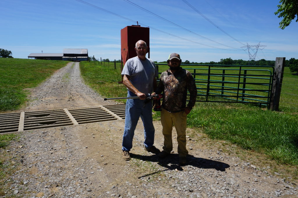 Two men standing in the road on a farm